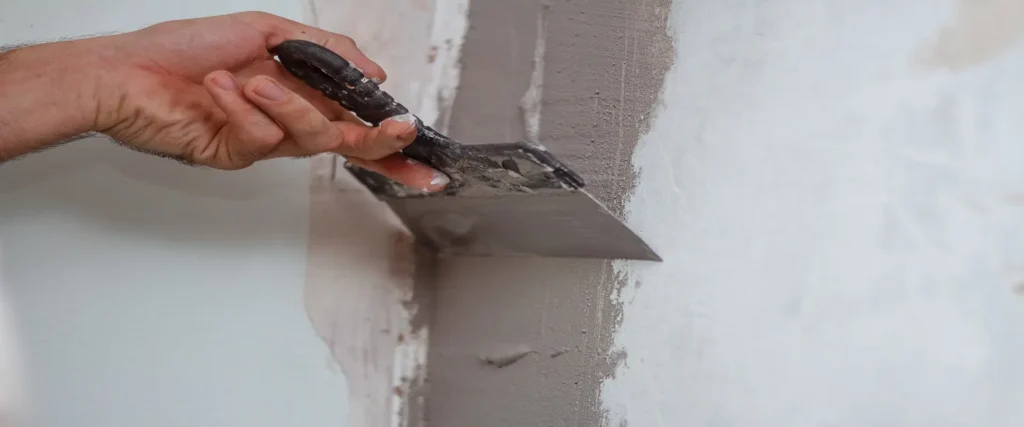 Profesional alisando una pared antes de realizar trabajos de pintura interior en Lleida